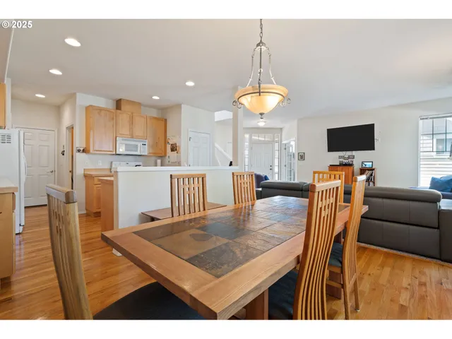 a kitchen with stainless steel appliances granite countertop a table chairs and a refrigerator