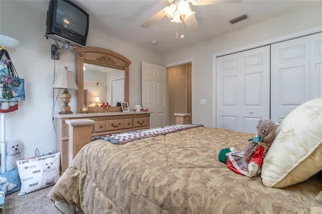 a bedroom with a bed a mirror and a lamp on dresser