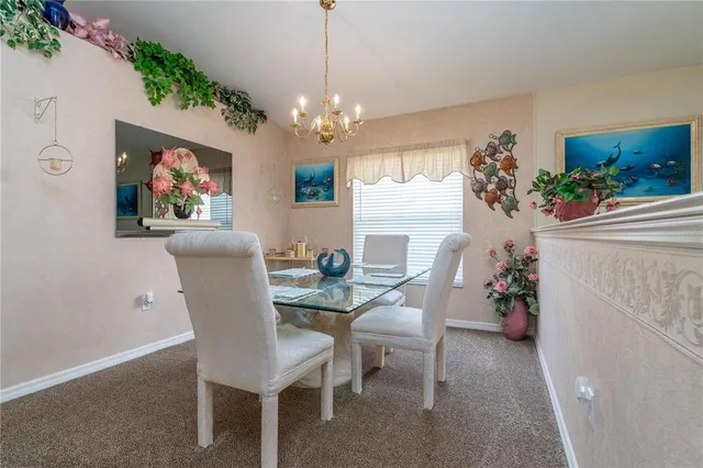 a view of a dining room with furniture and a chandelier