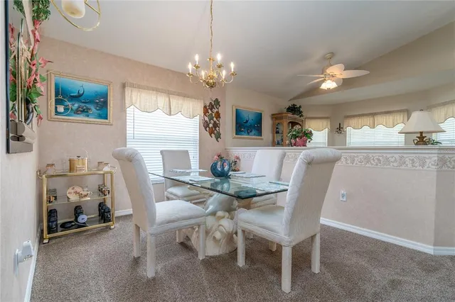 a view of a dining room with furniture a chandelier and wooden floor