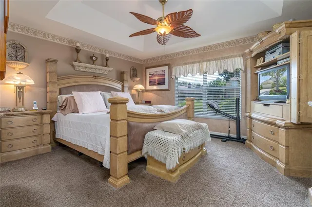 a bedroom with a bed and a flat tv screen on dresser