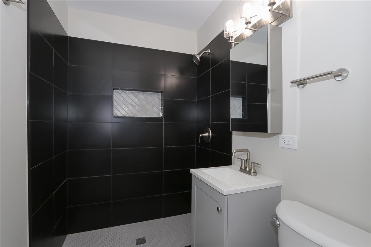 750 East Maple Street, Unit A Lombard, IL 60148 - Photo 16 of 26 a bathroom with a sink a toilet and a mirror