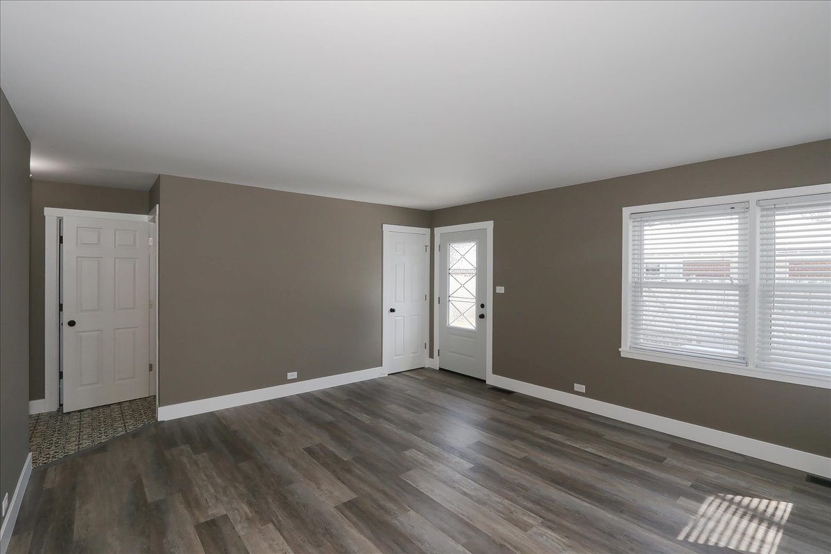 750 East Maple Street, Unit A Lombard, IL 60148 - Photo 5 of 26 an empty room with wooden floor and windows