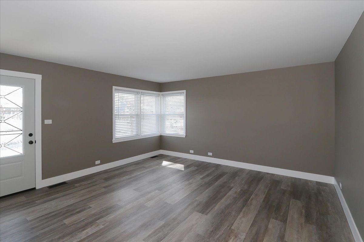 750 East Maple Street, Unit A Lombard, IL 60148 - Photo 7 of 26 an empty room with wooden floor and windows