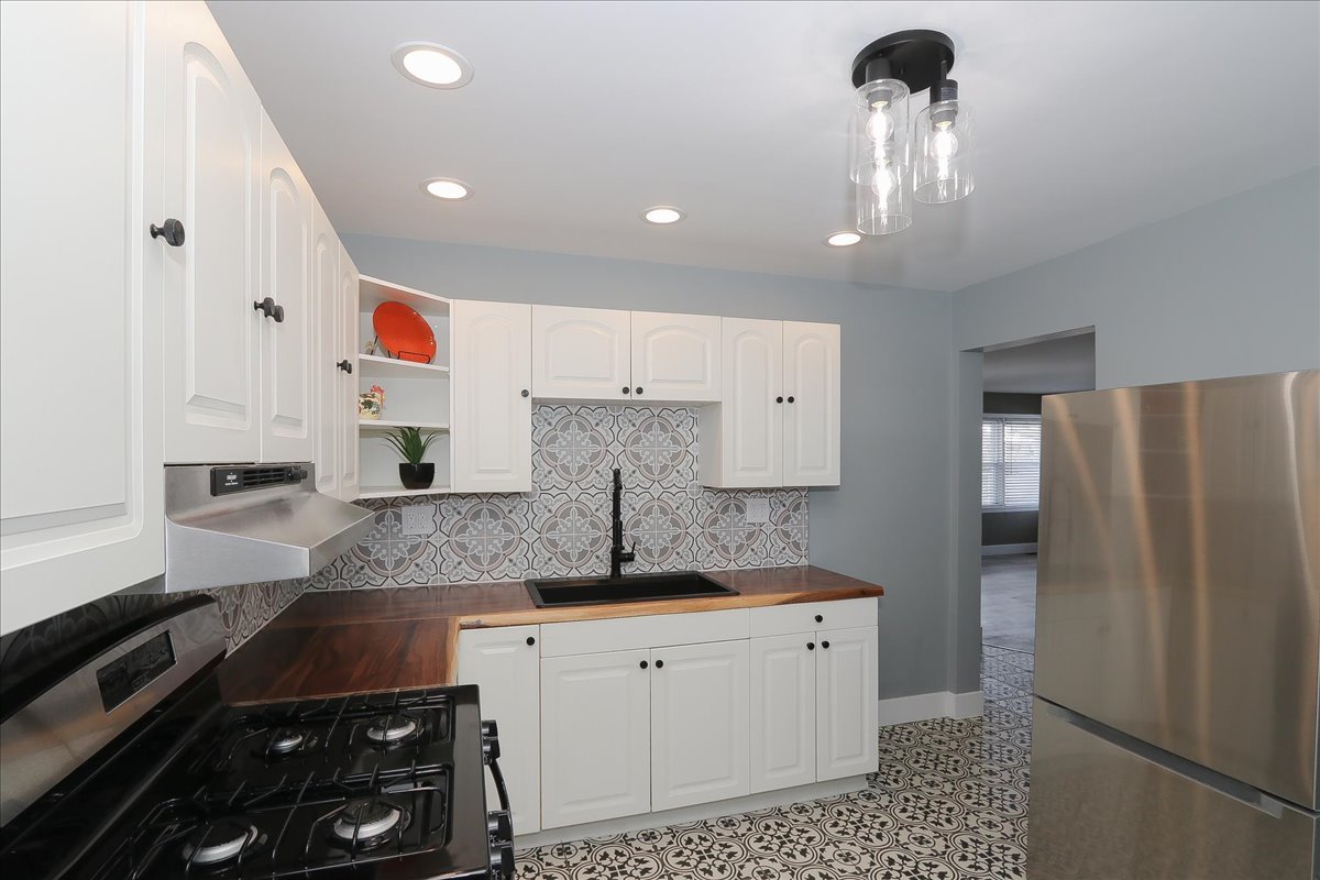 750 East Maple Street, Unit A Lombard, IL 60148 - Photo 10 of 26 a kitchen with granite countertop white cabinets and stainless steel appliances