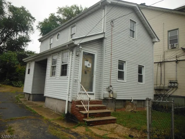 a view of house with a yard and large tree