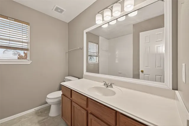 a bathroom with a sink a toilet and a mirror