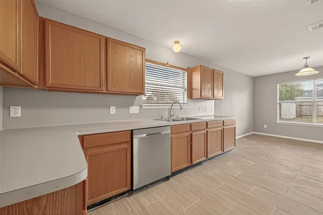 a kitchen with granite countertop cabinets stainless steel appliances a sink and a window