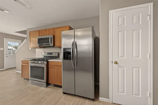 a kitchen with stainless steel appliances granite countertop a refrigerator and a stove top oven