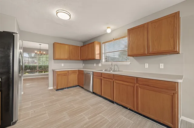 a large kitchen with granite countertop a sink stainless steel appliances and cabinets
