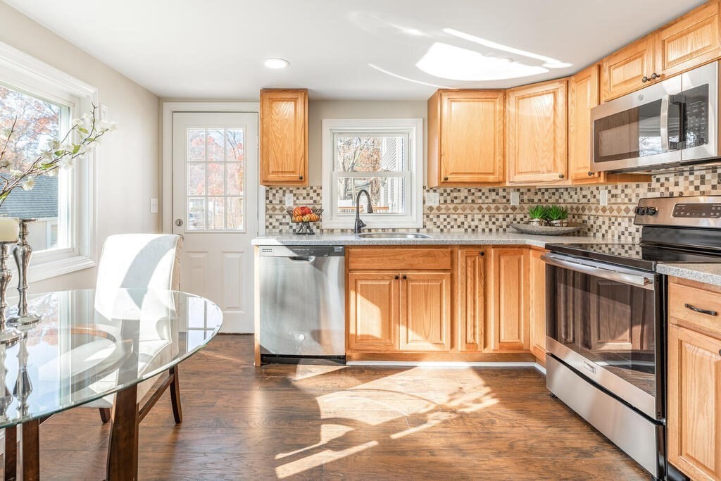 57 West Shore Road Holbrook, MA 02343 - Photo 6 of 13 a kitchen with stainless steel appliances granite countertop a stove a sink dishwasher and microwave with wooden floor