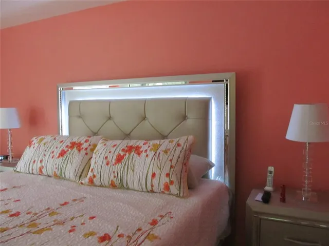 a bedroom with a bed and a lamp on dresser
