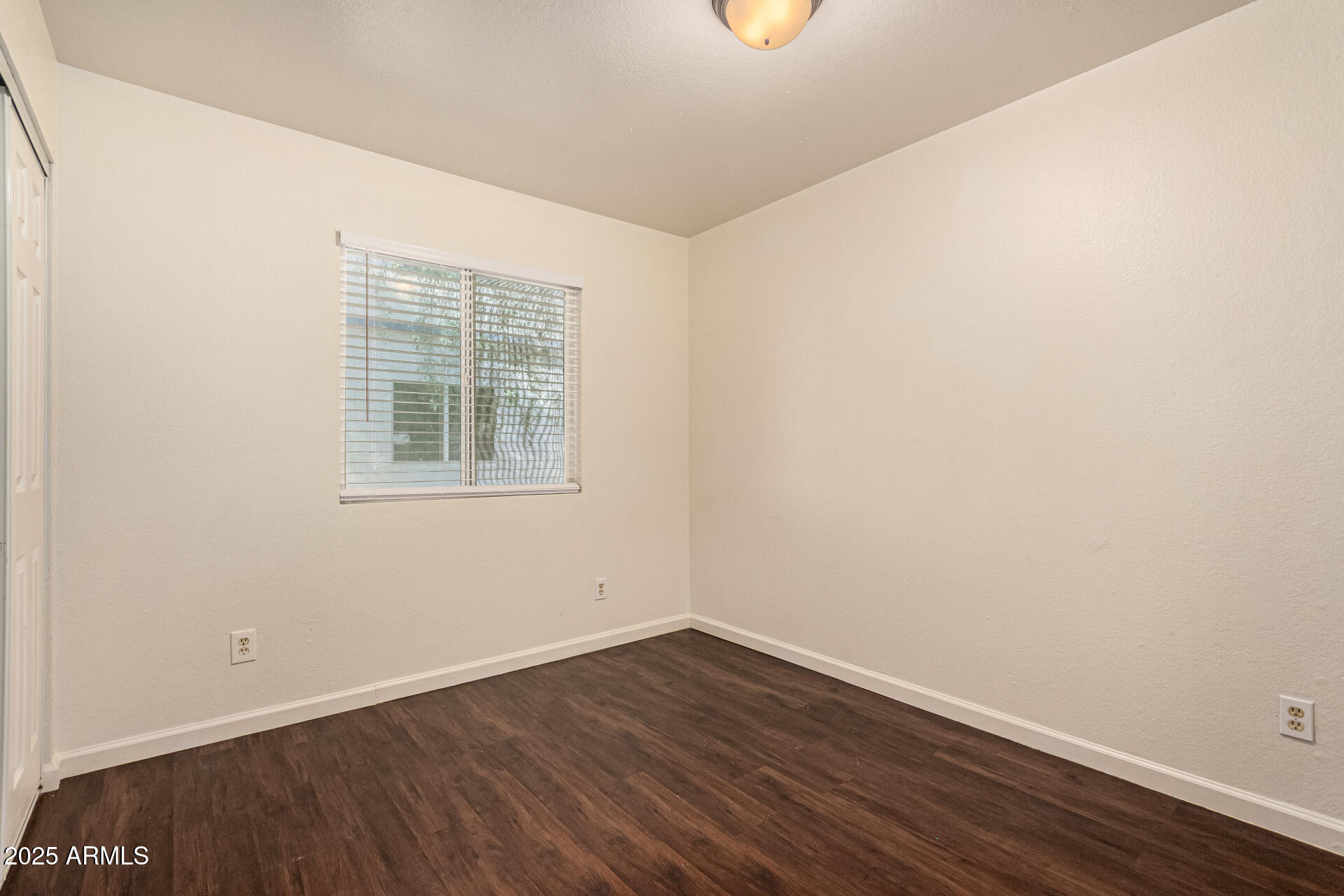 1318 East Culver Street, Unit 1 Phoenix, AZ 85006 - Photo 10 of 26 an empty room with wooden floor and windows