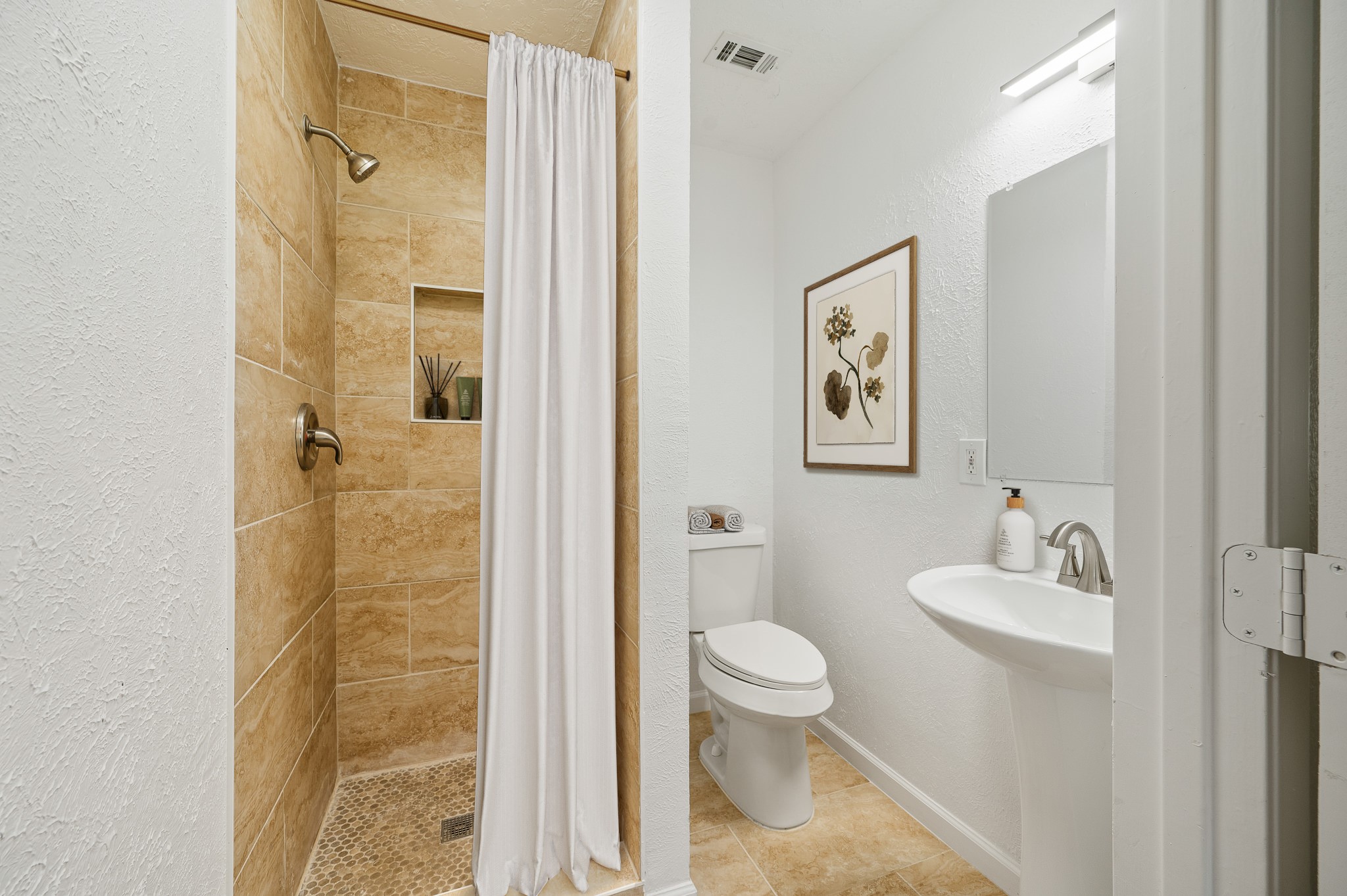 61 Hicks Loop West Cleveland, TX 77328 - Photo 28 of 38 Charming bathroom with a cozy tiled shower, elegant pedestal sink, and modern fixtures, complemented by tasteful wall art.