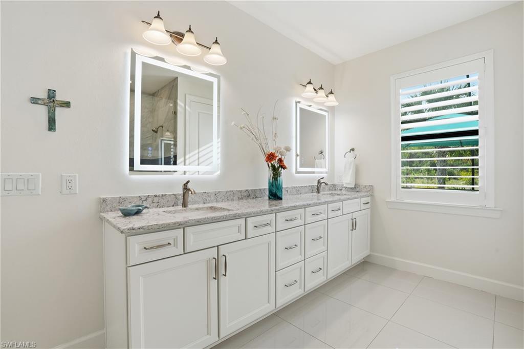 17210 Ashcomb Way Estero, FL 33928 - Photo 22 of 47 a bathroom with a granite countertop sink a large mirror a and a window