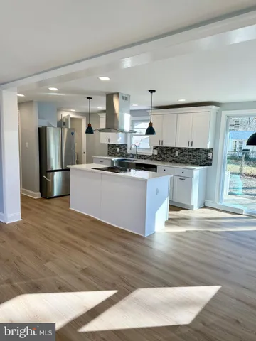 a large kitchen with stainless steel appliances kitchen island granite countertop a stove and a sink