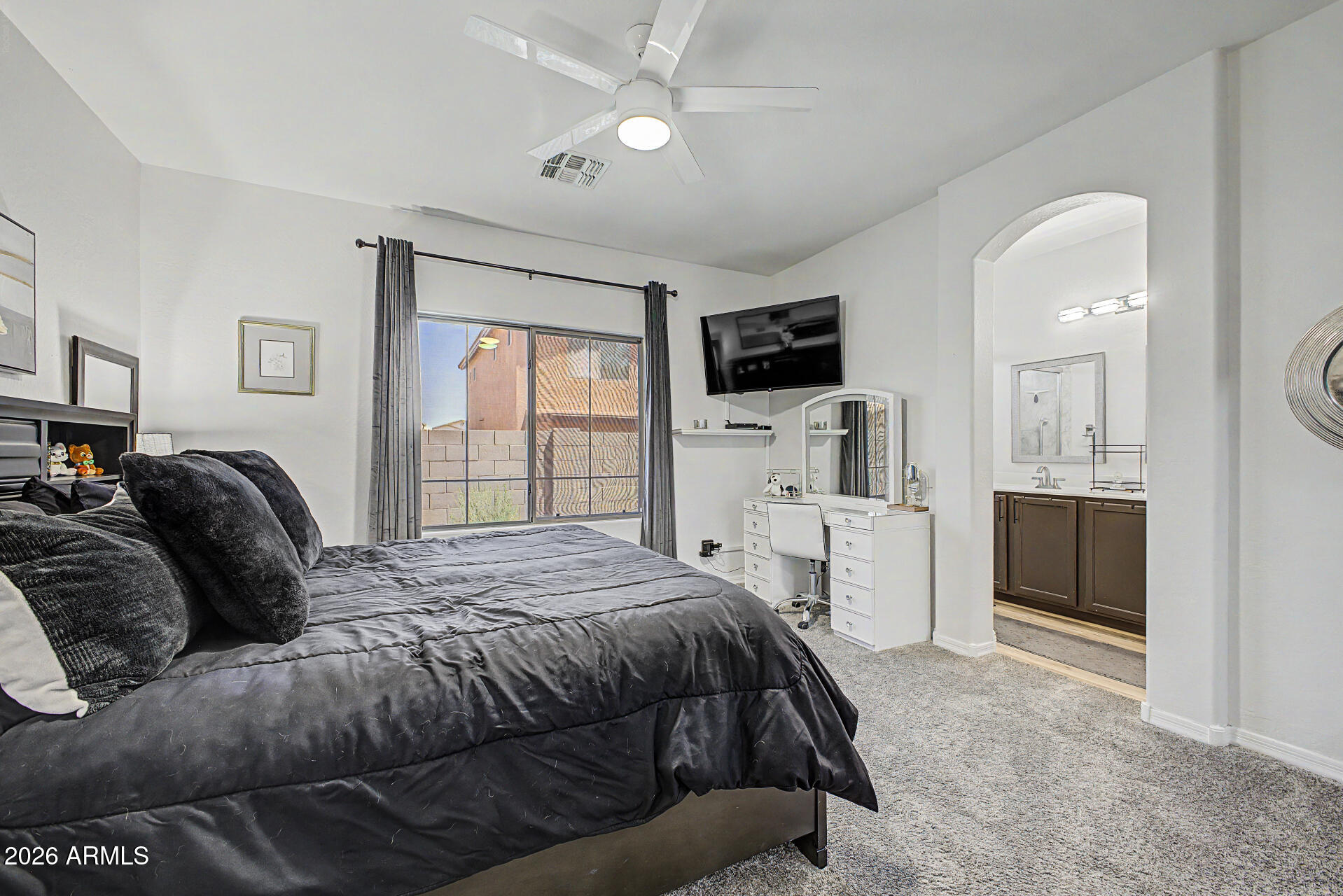 4924 West Harwell Road Laveen, AZ 85339 - Photo 13 of 27 a spacious bedroom with a bed a couch and a flat screen tv