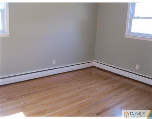 78 Brandywine Road Fords, NJ 08863 - Photo 12 of 13 a view of an empty room with wooden floor and a window