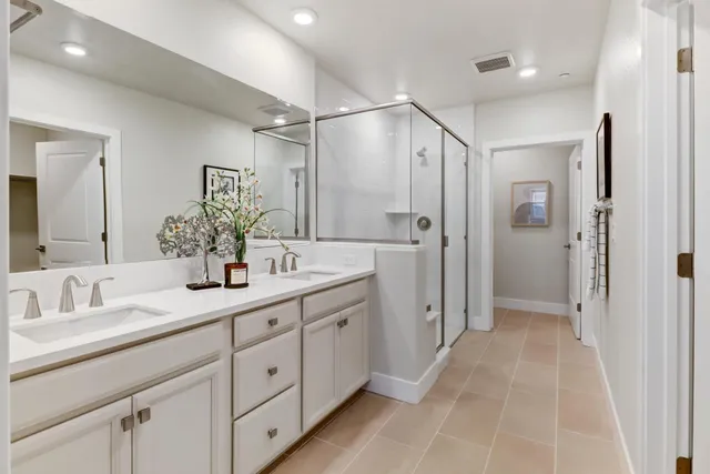 a spacious bathroom with a double vanity sink mirror and shower