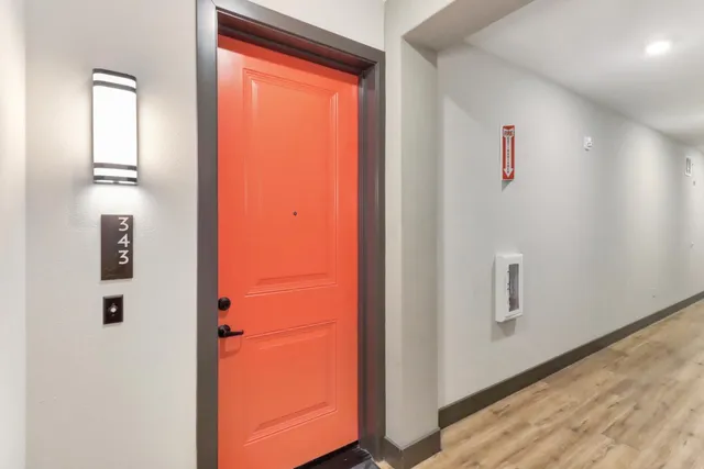 a view of a hallway with wooden floor and windows
