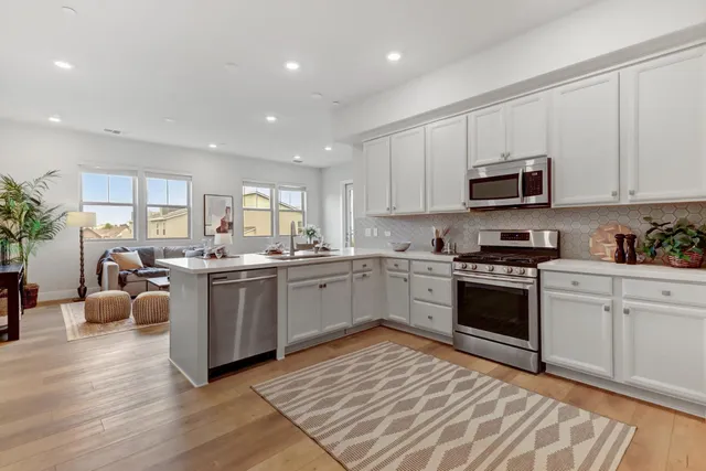 a kitchen with stainless steel appliances granite countertop a stove sink and cabinets