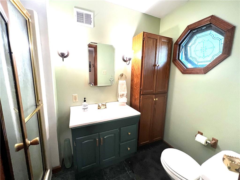 3121 Conway Wallrose Road Baden, PA 15005 - Photo 13 of 25 a bathroom with a toilet a sink and a mirror