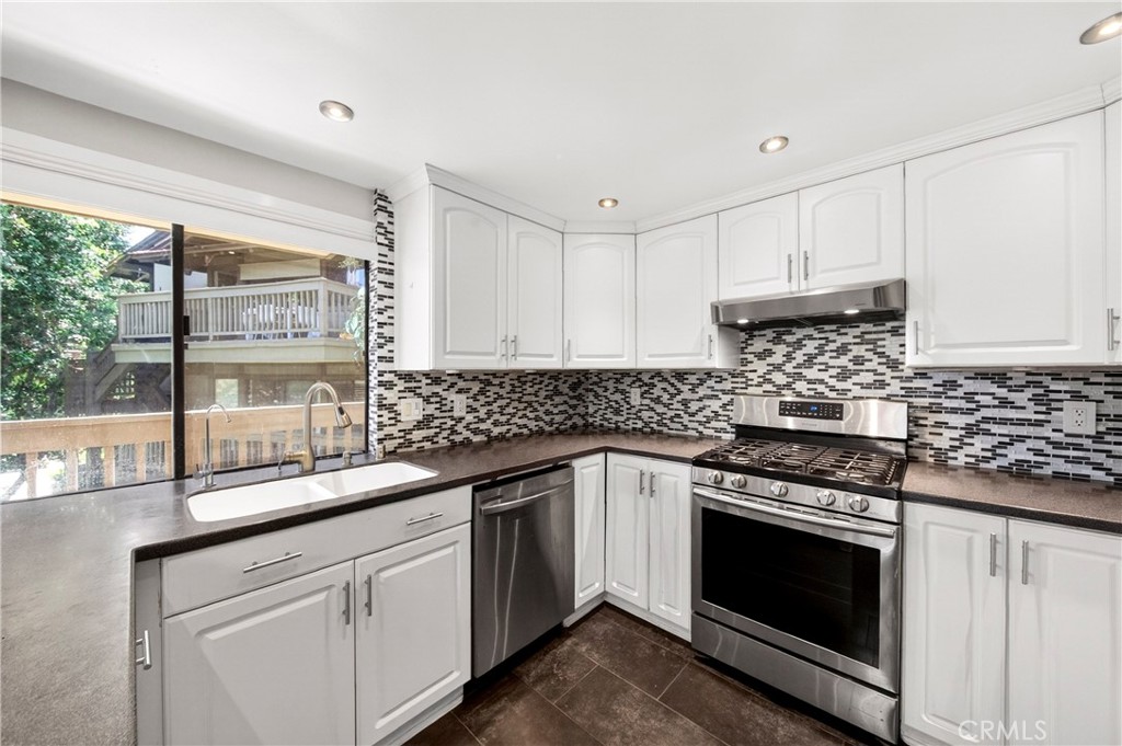 9 Madrona Irvine, CA 92612 - Photo 11 of 38 a kitchen with granite countertop white cabinets stainless steel appliances and a sink