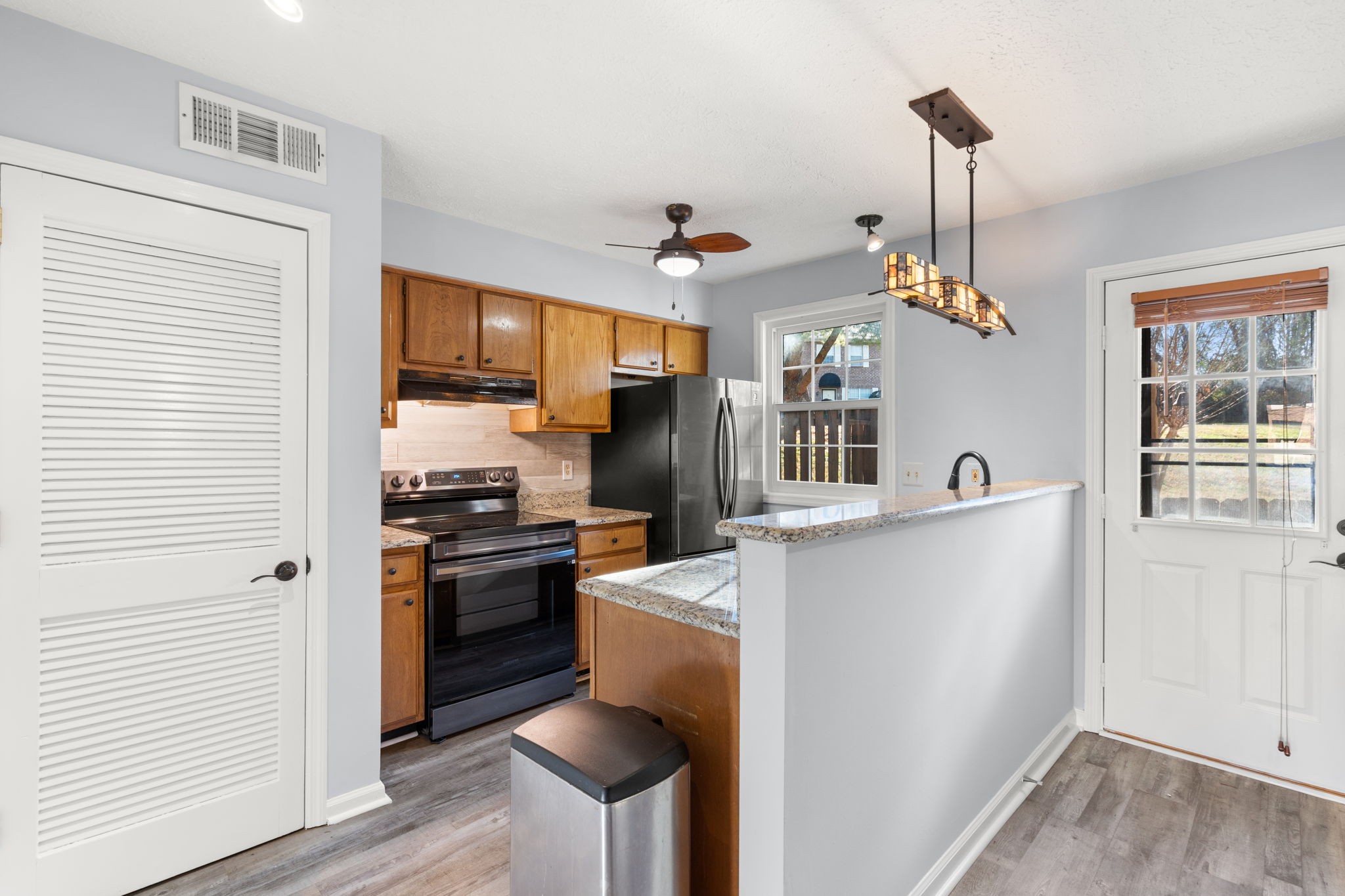 129 Thistle Lane Hermitage, TN 37076 - Photo 8 of 22 a kitchen with stainless steel appliances granite countertop a refrigerator a sink dishwasher a stove and a dining table with wooden floor