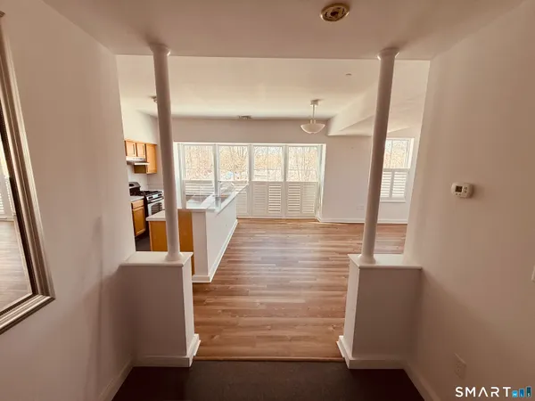 a view of a hallway with wooden floor and staircase