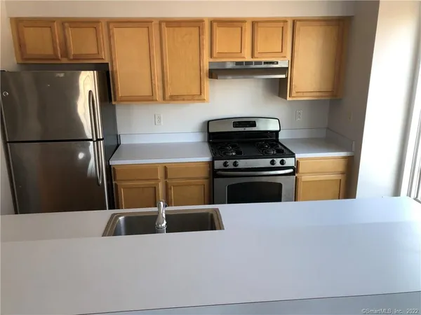a kitchen with stainless steel appliances a stove a refrigerator and cabinets