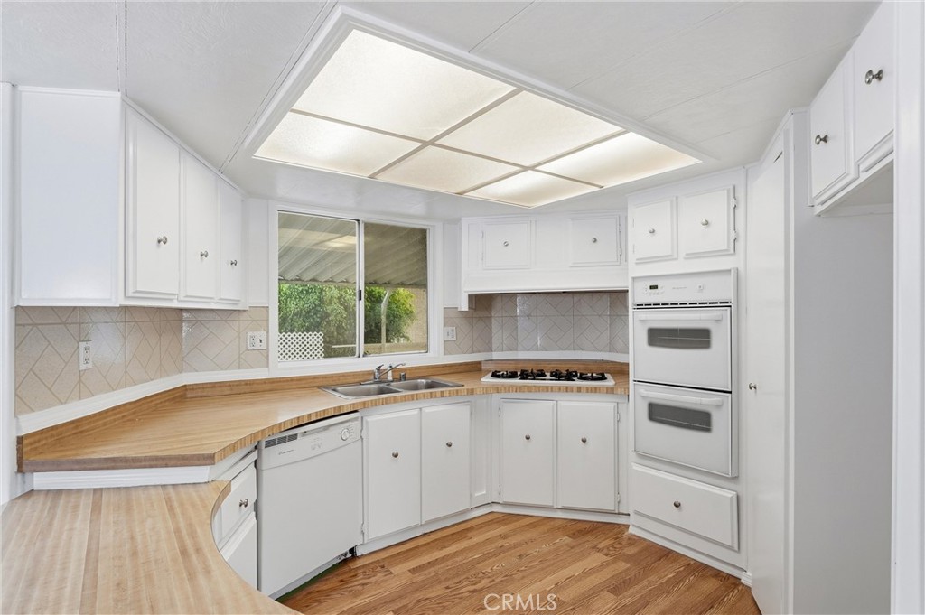 4901 Green River Road, Unit 140 Corona, CA 92878 - Photo 7 of 21 a kitchen with cabinets appliances a sink and a window