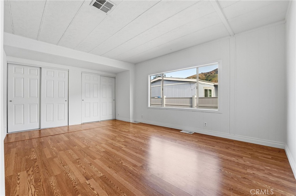 4901 Green River Road, Unit 140 Corona, CA 92878 - Photo 9 of 21 a view of an empty room with a window and wooden floor