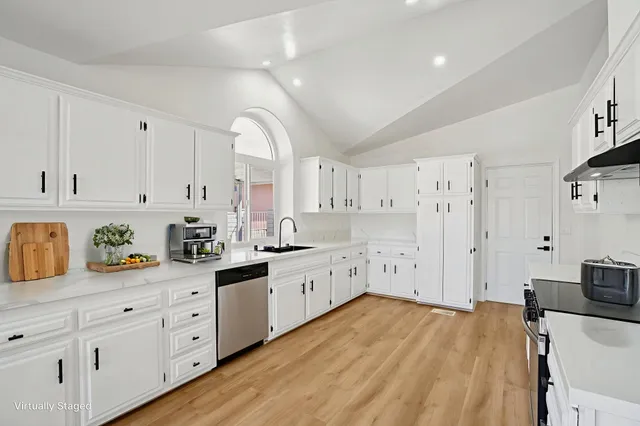 a large kitchen with cabinets and wooden floor