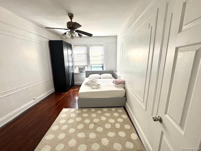 45-47 43rd Street Queens, NY 11104 - Photo 14 of 26 Bedroom featuring dark wood-style floors, a ceiling fan, and a decorative wall