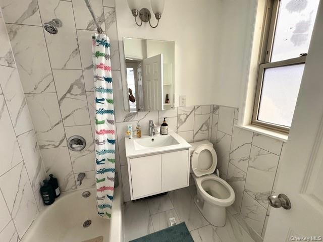 45-47 43rd Street Queens, NY 11104 - Photo 17 of 26 Bathroom featuring shower / tub combo with curtain, vanity, tile walls, and light marble finish floors