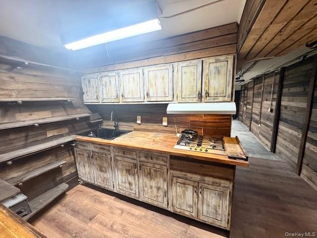 45-47 43rd Street Queens, NY 11104 - Photo 21 of 26 Bar featuring wooden walls, light wood-style flooring, stainless steel gas cooktop, and range hood