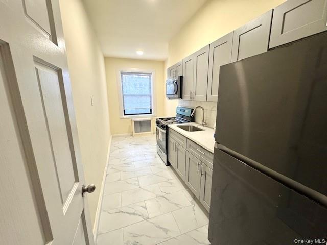 45-47 43rd Street Queens, NY 11104 - Photo 6 of 26 Kitchen with appliances with stainless steel finishes, gray cabinets, light marble finish flooring, light stone counters, and recessed lighting