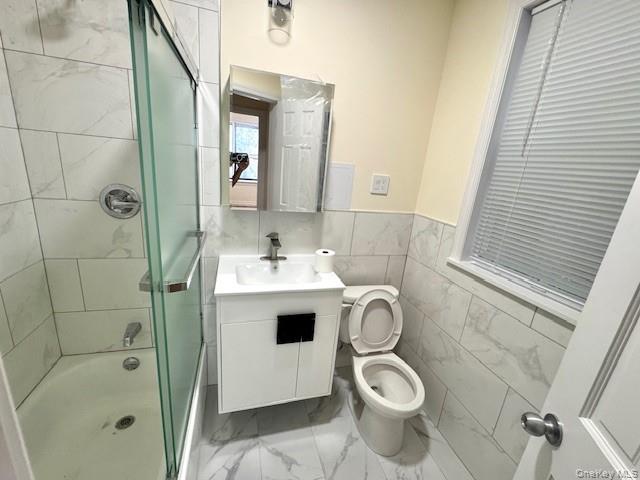 45-47 43rd Street Queens, NY 11104 - Photo 7 of 26 Bathroom with vanity, shower / bath combination with glass door, tile walls, light marble finish flooring, and a wainscoted wall