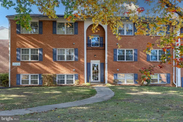 a view of a big yard in front of a brick house with a large windows