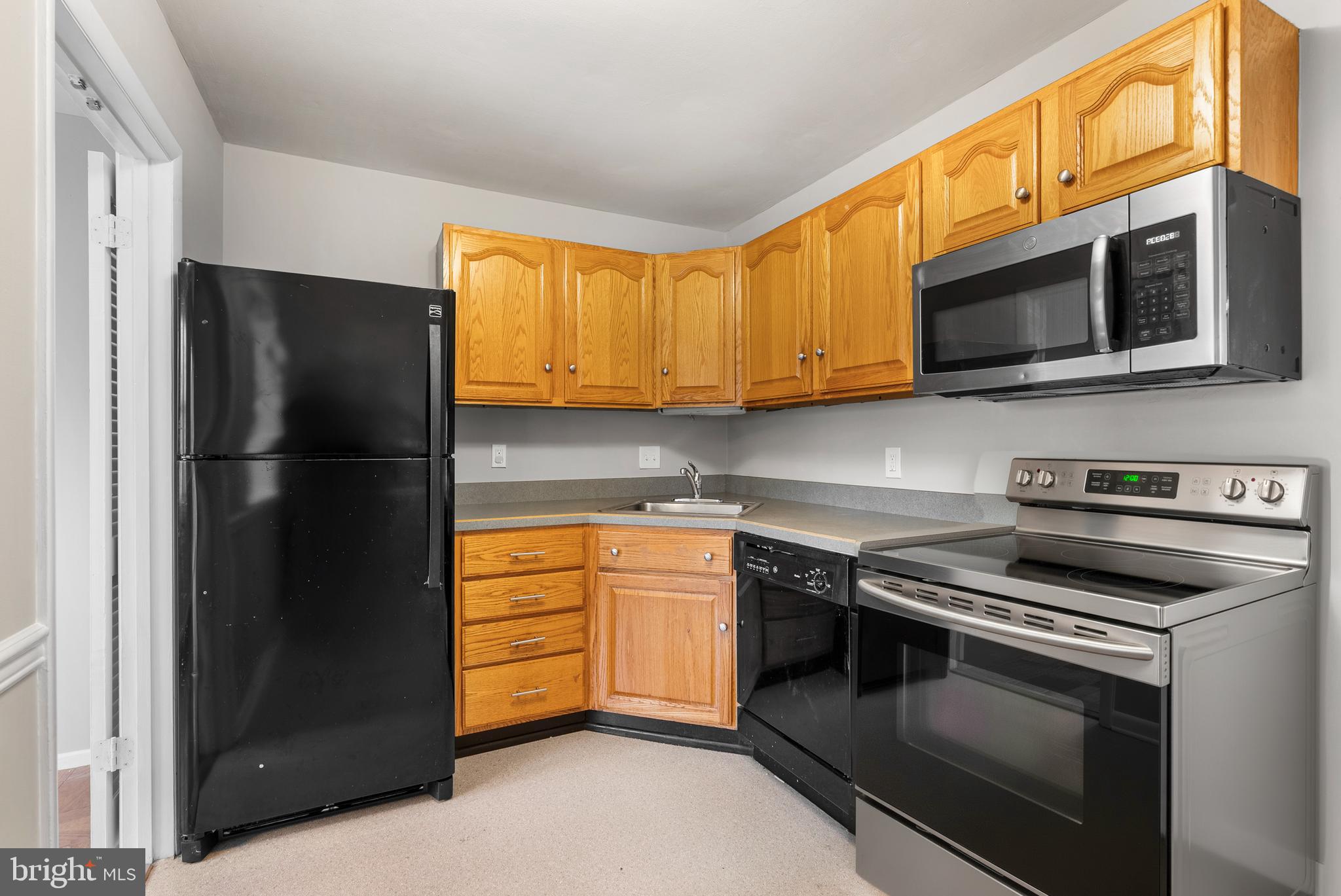 240 Crocker Drive, Unit 240F Bel Air, MD 21014 - Photo 3 of 38 a kitchen with stainless steel appliances granite countertop a refrigerator stove and microwave