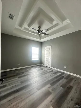 an empty room with window and ceiling fan