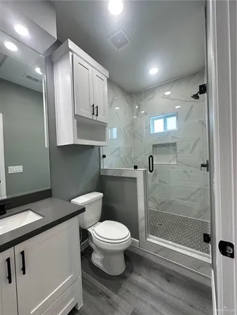 a bathroom with a toilet a sink and shower