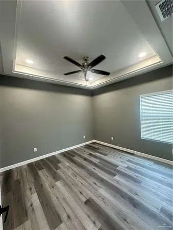 an empty room with a ceiling fan and window