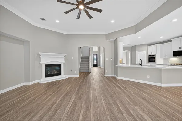 a view of a big room with wooden floor and a kitchen