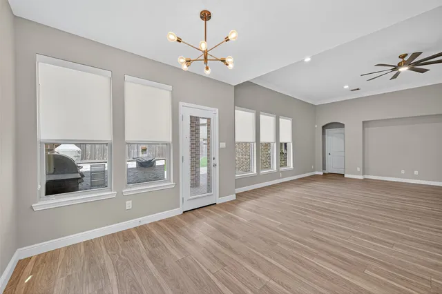 a view of a room with wooden floor and ceiling fan