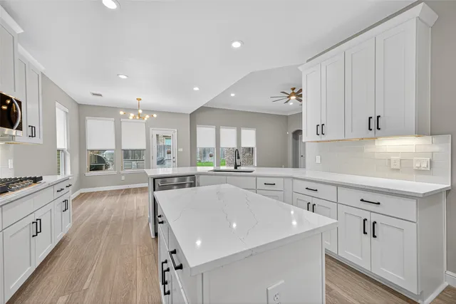 a kitchen with white cabinets sink and stove