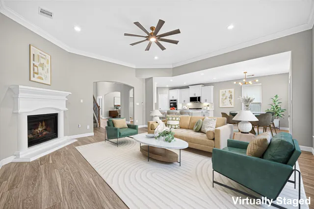 a living room with furniture a fireplace and a ceiling fan