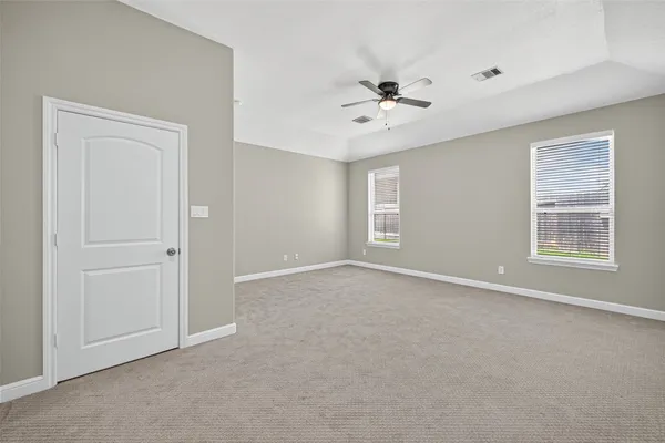an empty room with closet and a ceiling fan