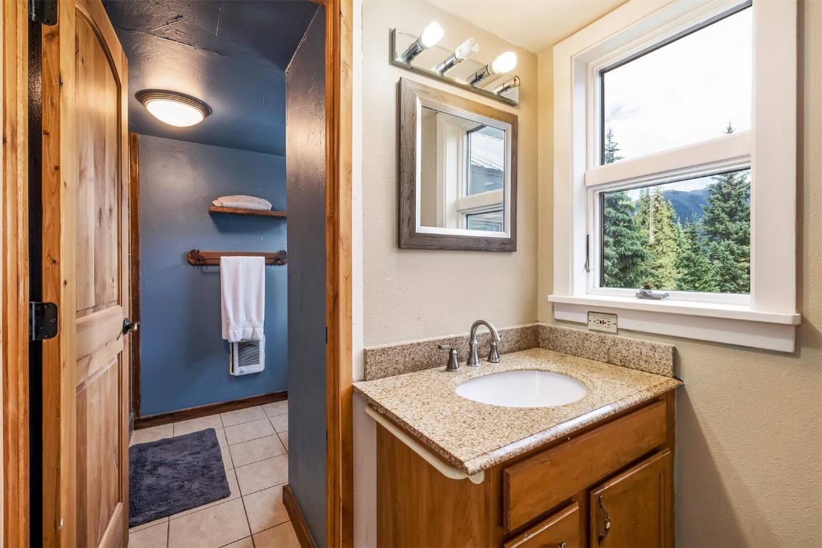 5115 Montezuma Road Montezuma, CO 80435 - Photo 15 of 35 a bathroom with a granite countertop sink and a mirror
