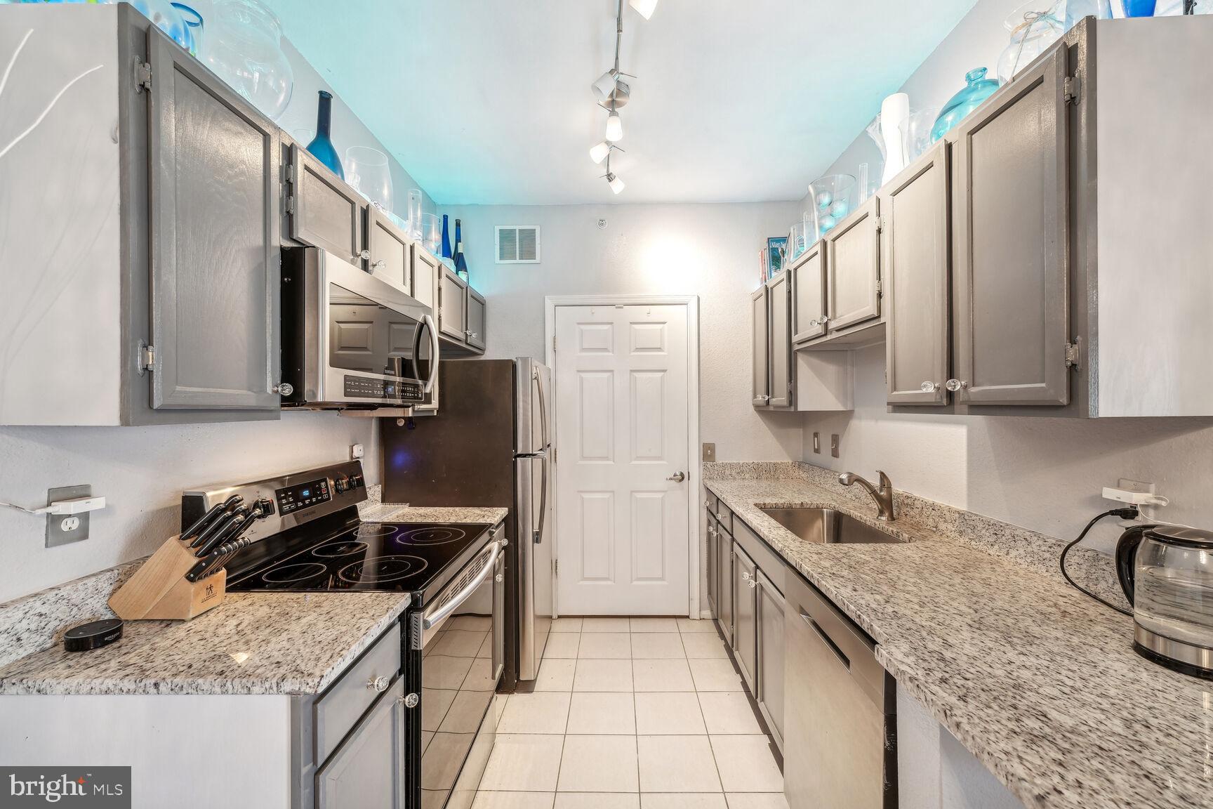 1581 Spring Gate Dr., Unit 5403 McLean, VA 22102 - Photo 4 of 20 a kitchen with stainless steel appliances granite countertop a sink stove and refrigerator